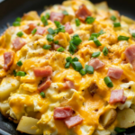 Cheesy Potato Egg Scramble Recipe: The Ultimate Easy Breakfast Skillet Everyone Loves If you are craving a cozy, filling breakfast that feels indulgent but is incredibly easy to make, this Cheesy Potato Egg Scramble Recipe is about to become your new go-to. It is warm, comforting, packed with flavor, and made with simple ingredients you probably already have in your kitchen. Whether you are cooking for a lazy weekend brunch, a quick weekday breakfast, or even breakfast-for-dinner, this recipe delivers every single time. Why You’ll Love This Cheesy Potato Egg Scramble This recipe checks all the right boxes. It is quick, budget-friendly, customizable, and incredibly satisfying. The crispy potatoes paired with soft scrambled eggs and melty cheese create the perfect texture combination. It is also a one-pan meal, which means fewer dishes and less cleanup. Plus, it is easy to scale up if you are feeding a crowd or meal prepping for the week. Serving Size and Time Breakdown Serving Size: Serves 2 to 3 people Prep Time: 10 minutes Cook Time: 20 minutes Total Time: 30 minutes Kitchen Equipment Required You do not need anything fancy to make this recipe. Just a few basic tools will do the job. Large non-stick skillet or cast iron pan Cutting board Sharp knife Mixing bowl Spatula Measuring cups and spoons Ingredients 2 cups diced potatoes (russet or Yukon gold work best) 1 tablespoon olive oil or butter 4 large eggs 1 cup shredded cheddar cheese (or cheese of choice) 1 small onion, diced 1 clove garlic, minced Salt, to taste Black pepper, to taste Optional additions: bell peppers, green onions, cooked bacon or sausage How to Make Cheesy Potato Egg Scramble Heat the olive oil or butter in a large skillet over medium heat. Add the diced potatoes and cook for 10 to 12 minutes, stirring occasionally, until they are golden brown and fork-tender. Add the diced onion and minced garlic to the skillet and cook for another 2 to 3 minutes until fragrant and softened. In a bowl, whisk the eggs with a pinch of salt and black pepper. Reduce the heat to medium-low and pour the eggs into the skillet with the potatoes. Gently stir until the eggs are just set but still soft. Sprinkle the shredded cheese over the top and allow it to melt. Remove from heat and serve immediately. Tips for Making the Best Potato Egg Scramble Cut the potatoes into small, even pieces so they cook evenly. If you are short on time, you can parboil the potatoes for a few minutes before pan-frying them. Always lower the heat before adding the eggs to avoid overcooking. Use freshly shredded cheese for the best melting and flavor. Common Mistakes to Avoid Avoid overcrowding the pan, as this can cause the potatoes to steam instead of crisp. Do not cook the eggs on high heat or they will become dry and rubbery. Skipping seasoning early can result in bland potatoes, so season as you cook. Variations and Substitutions You can easily customize this recipe to fit your preferences. Swap cheddar for mozzarella, pepper jack, or Swiss cheese. Add spinach, mushrooms, or tomatoes for extra veggies. For a protein boost, mix in cooked sausage, ham, or bacon. To make it dairy-free, use plant-based butter and dairy-free cheese alternatives. How to Store and Meal Prep Store leftovers in an airtight container in the refrigerator for up to 3 days. To reheat, warm gently in a skillet or microwave until heated through. This recipe is great for meal prep. Simply portion it out and pair with toast or fruit for an easy grab-and-go breakfast. Serving and Presentation Ideas Serve this cheesy potato egg scramble straight from the skillet for a rustic breakfast feel. Garnish with chopped green onions or fresh herbs. Pair it with toast, avocado slices, or a side of fresh fruit for a complete meal. It also works great wrapped in a tortilla as a breakfast burrito. Frequently Asked Questions Can I use frozen potatoes? Yes, frozen diced potatoes or hash browns work well. Just make sure to cook off any excess moisture. Can I make this recipe ahead of time? Yes, you can prepare it ahead and reheat it gently. The texture is best when freshly made, but leftovers still taste great. What is the best pan to use? A non-stick skillet or cast iron pan works best to prevent sticking and achieve crispy potatoes. Can I make this recipe healthier? Use less cheese, add more vegetables, and cook with olive oil instead of butter for a lighter version. Conclusion Cheesy Potato Egg Scramble